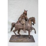 A bronze model of a king on horseback, with a sword in his left hand and right hand open,