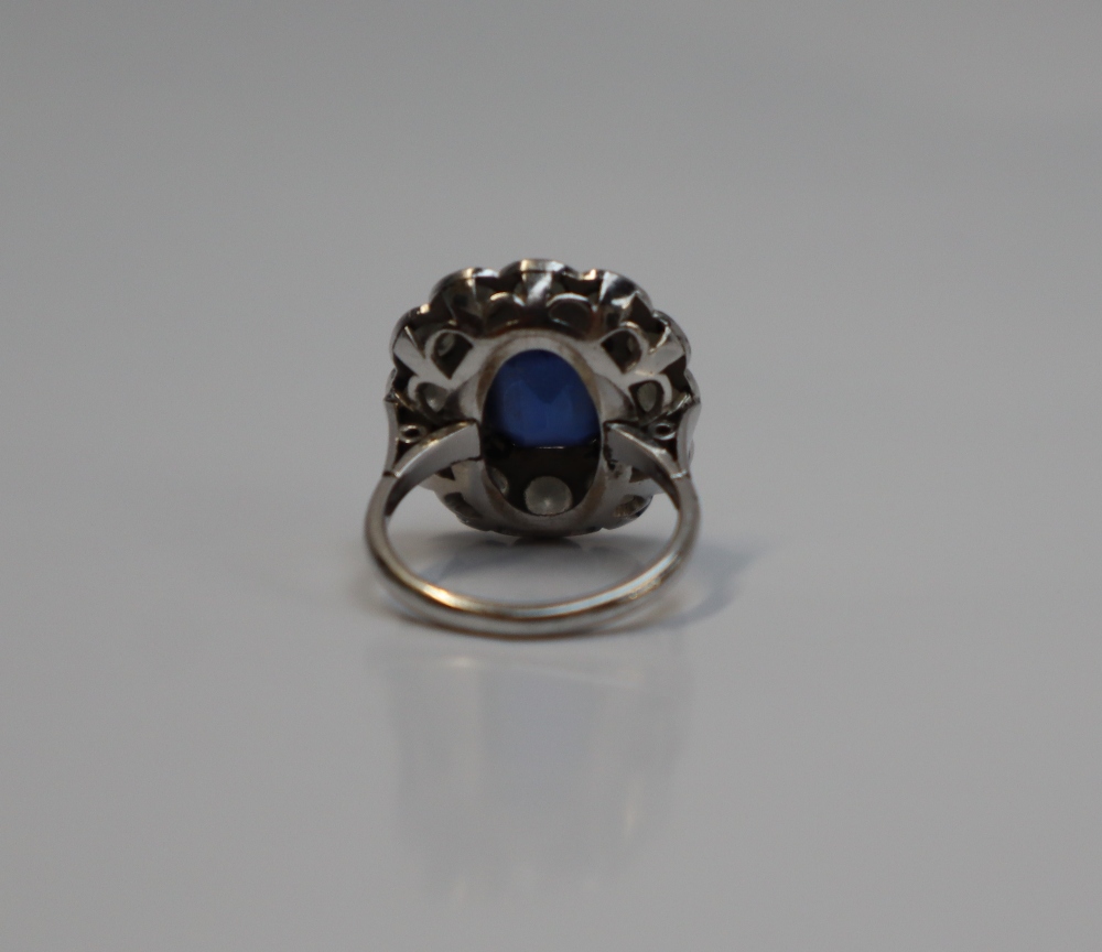 A sapphire and diamond cluster ring, the emerald cut sapphire approximately 11mm x 8mm, - Image 5 of 6