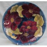 A Moorcroft pottery plate, decorated in the clematis pattern,