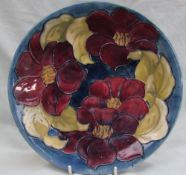 A Moorcroft pottery plate, decorated in the clematis pattern,