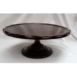 A Victorian mahogany Lazy Susan, the circular top with gouged edge, on a capstan shaped pedestal,