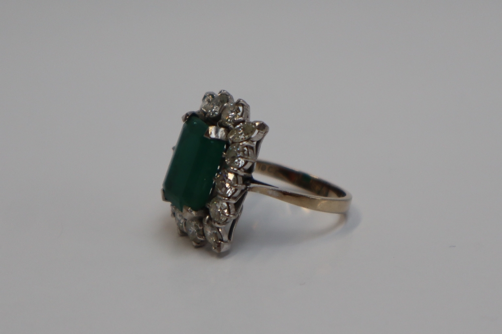 An emerald and diamond cluster ring, the central emerald cut emerald approximately 12mm x 9mm, - Image 2 of 7