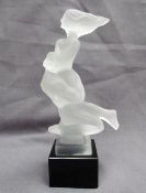 A frosted glass mascot of nude lovers in the style of H Hoffmann, on a black glass plinth,