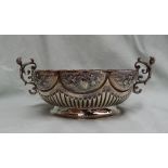 A Victorian silver twin handled lobed bowl decorated with flower heads and fruit with a reeded body