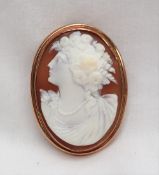 A shell cameo brooch depicting a maiden in profile with flowers in her hair,