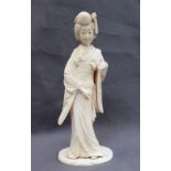 A 19th century Japanese Ivory figure of a geisha, in traditional dress, on an oval base,