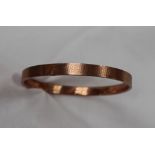 A 9ct yellow gold bangle, with engine turned decoration, approximately 12 grams,