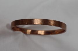 A 9ct yellow gold bangle, with engine turned decoration, approximately 12 grams,