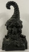 A cast iron door stop in the form of a gnome with a curling hat, 24.