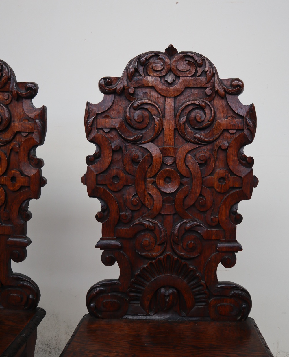 A pair of continental carved oak hall chairs, the back decorated with scrolling leaves and a shell, - Image 4 of 11