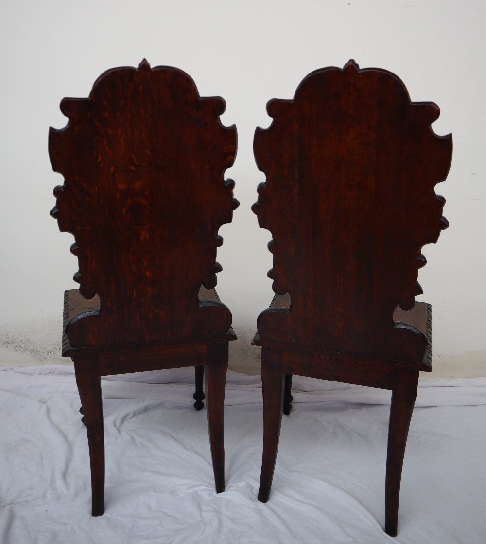 A pair of continental carved oak hall chairs, the back decorated with scrolling leaves and a shell, - Image 9 of 11