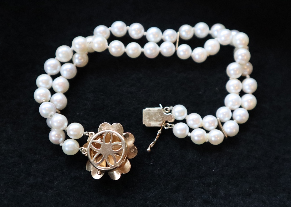 A pearl bracelet, with two rows of regular pearls, to a yellow metal floral shaped clasp, - Image 2 of 2