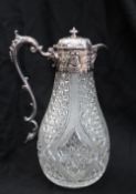 An Edward VII silver and cut glass claret jug, the domed top decorated with flowers and leaves,