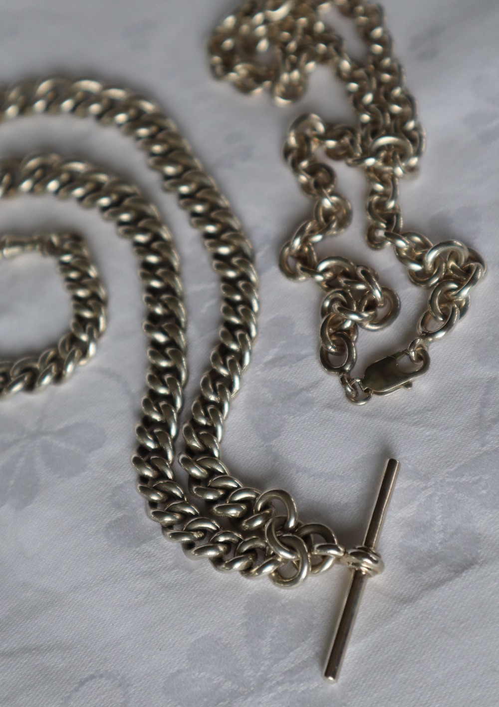 A silver Albert watch chain together with a silver necklace,