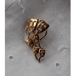 A 9ct yellow gold brooch depicting graduated theatrical masks, approximately 5.