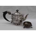 A Victorian silver teapot, the domed top embossed with leaves, above a flared rim,