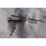 A white metal bar brooch, set with a round old cut diamond in a rubover setting, approximately 2.