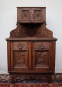 A 19th century carved oak Low Countries corner cabinet, with a pair of cupboard doors to the top,