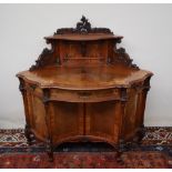 A 19th century French Walnut Lady's writing desk, with a raised carved cresting above a shelf,