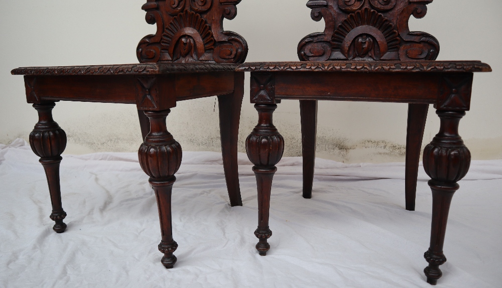 A pair of continental carved oak hall chairs, the back decorated with scrolling leaves and a shell, - Image 7 of 11