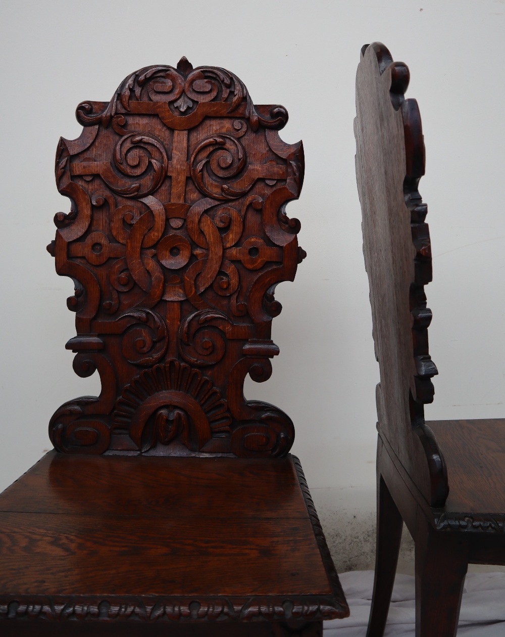 A pair of continental carved oak hall chairs, the back decorated with scrolling leaves and a shell, - Image 2 of 11