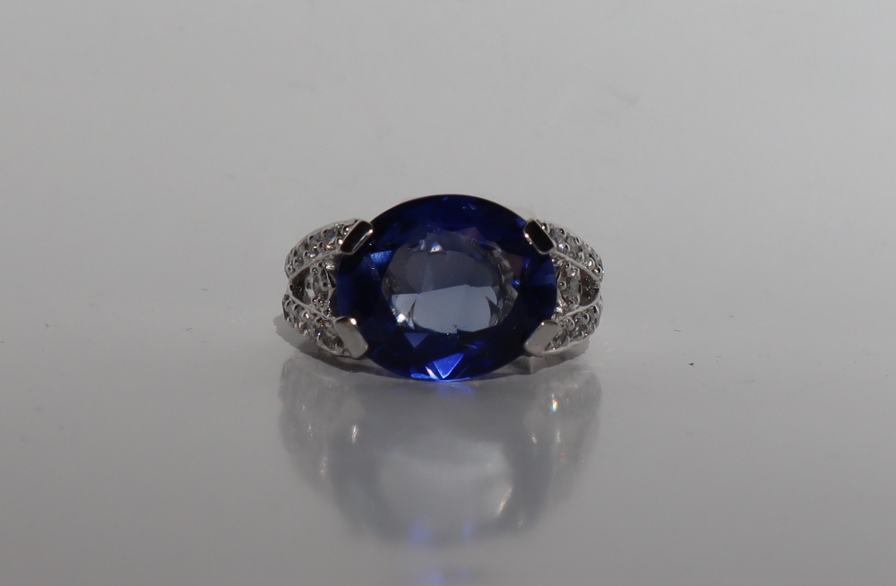 A sapphire and diamond ring, the oval faceted sapphire 14mm x 7mm,