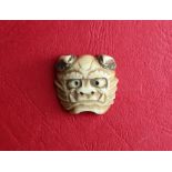 A Japanese stag antler Oni mask netsuke, signed,