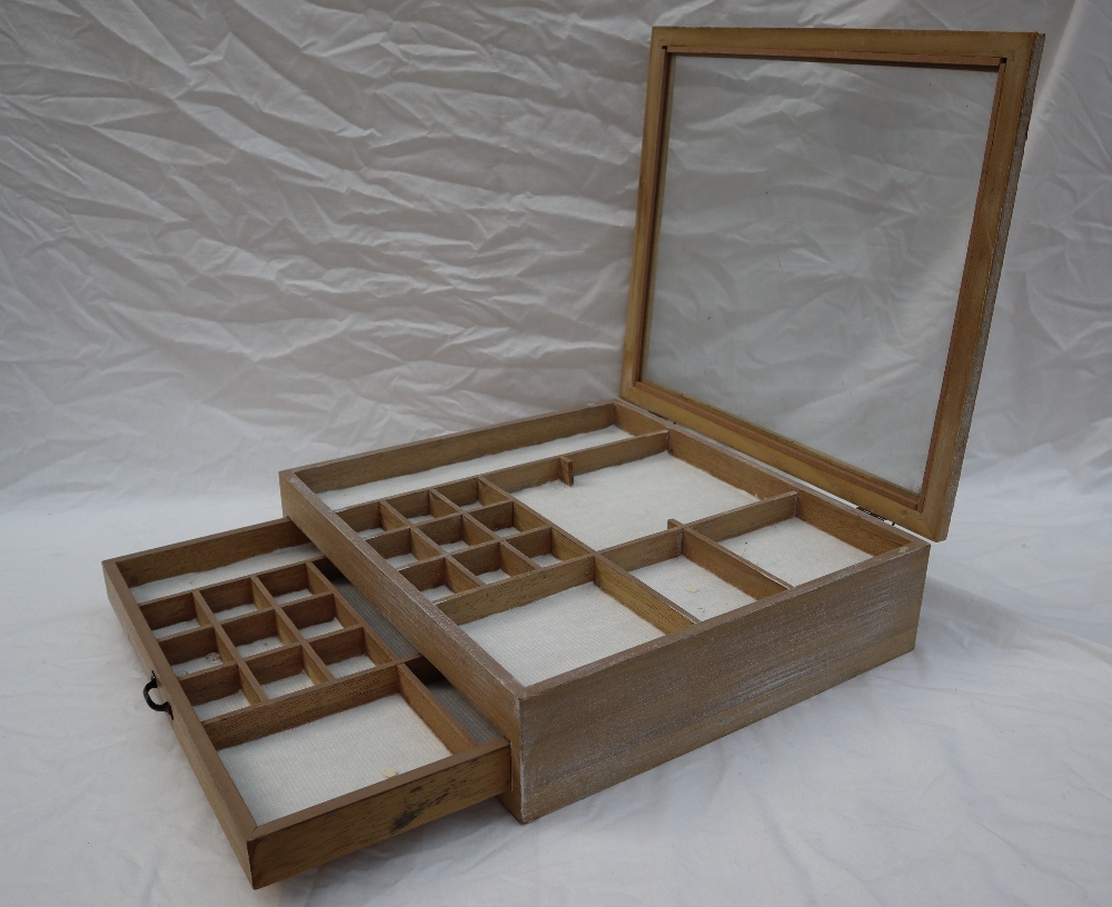 A small table top display cabinet, with a glazed top and sectional interior, above a base drawer,