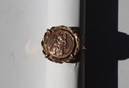 A 9ct yellow gold ring, set with a 9ct gold St Christopher, approximately 4.