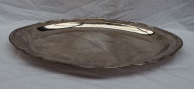 A large white metal tray of lobed form with a beaded rim and armorial, 58.