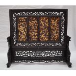 A Chinese hardwood and tortoiseshell table screen, with carved pierced decoration,
