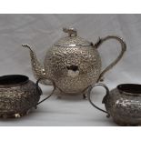An Indian white metal matched three piece teaset, the teapot with an elephant finial,