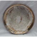 An Elizabeth II silver tray of circular form, with a beaded rim,