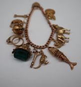 A 9ct yellow gold charm bracelet, set with numerous charms including a St Christopher, fan,
