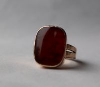 A yellow metal signet ring, with a hardstone panel to a yellow metal mount and shank marked 9ct,