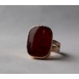 A yellow metal signet ring, with a hardstone panel to a yellow metal mount and shank marked 9ct,