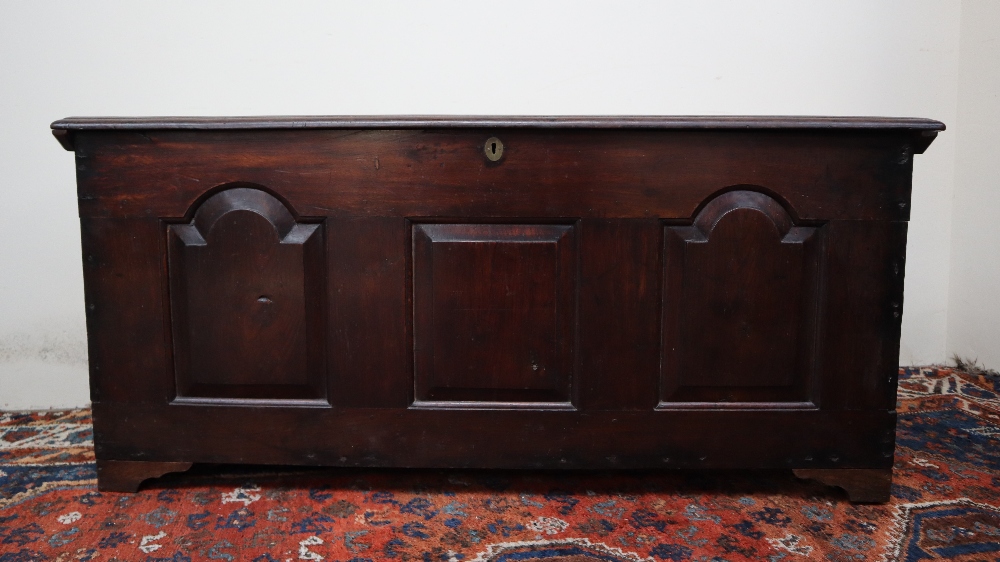 An 18th century oak coffer, the planked rectangular top above a three panelled front on stiles, - Image 2 of 5