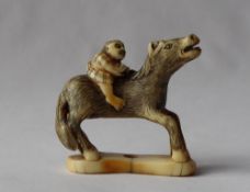 A 19th century Japanese ivory netsuke depicting a boy on a horse,