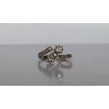 A Diamond crossover ring set with two round brilliant cut diamonds, each approximately 0.