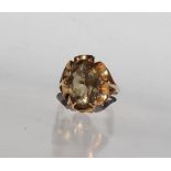 A smoky quartz dress ring, the oval faceted stone to a 9ct yellow gold setting and shank,