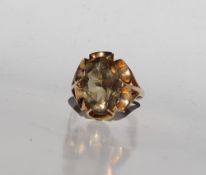 A smoky quartz dress ring, the oval faceted stone to a 9ct yellow gold setting and shank,