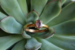 A ruby ring, the oval faceted ruby to a 22ct yellow gold setting and shank, size R, approximately 5.