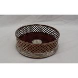 A modern silver wine coaster, with a lattice work edge and a turned mahogany base, 12.