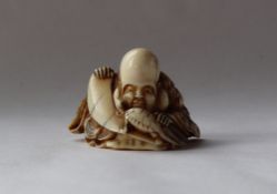 A 19th century Japanese ivory netsuke, depicting Fukurokuju with a turtle,