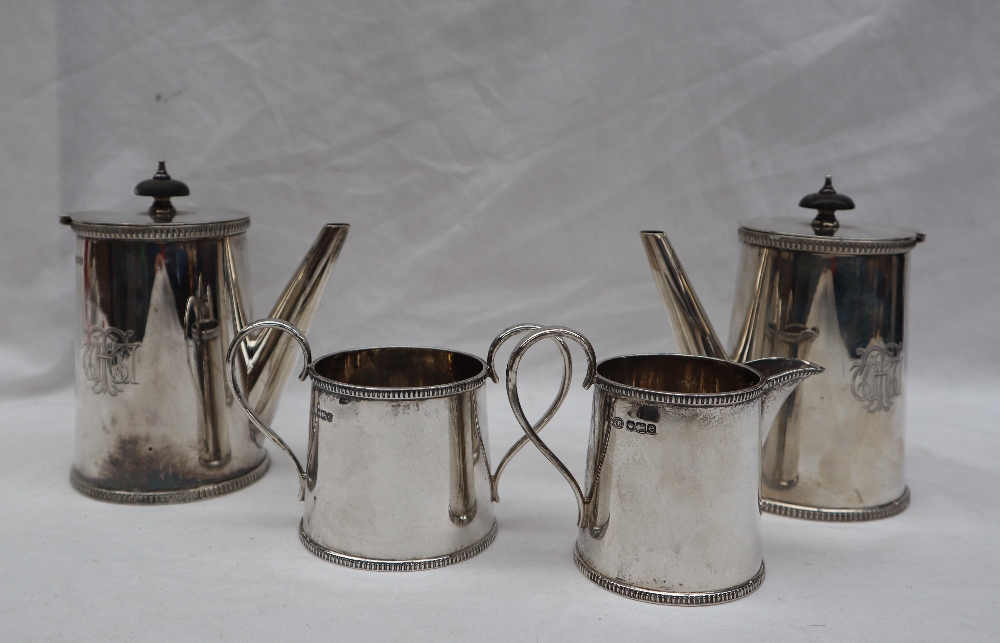 A George V silver four piece set comprising a pair of chocolate pots,