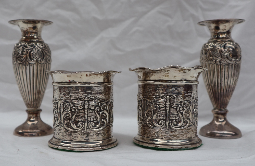 A pair of Edward VII silver vases with flared rims above a cylindrical body embossed with scrolls