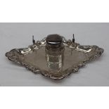 An Edward VII Silver desk standish, of pointed form, the edge moulded with leaves,
