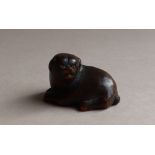 A 19th century Japanese carved wooden netsuke in the form of a recumbent dog, signed,