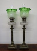 A matched pair of Victorian oil lamps with green to clear graded shades above a faceted clear glass