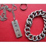 A silver ingot on a chain together with a heavy link silver bracelet, and a silver ring,